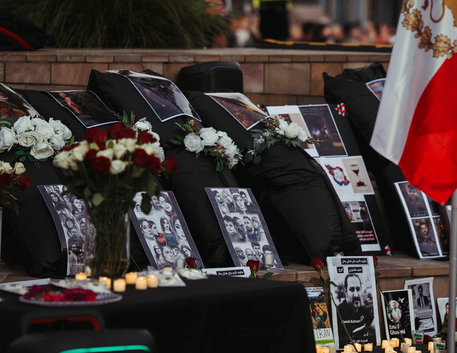 ALSA Chehelom memorial at Federation Square, 17–18 February 2026, with candles, flowers and photographs of those lost in the Lion and Sun Revolution